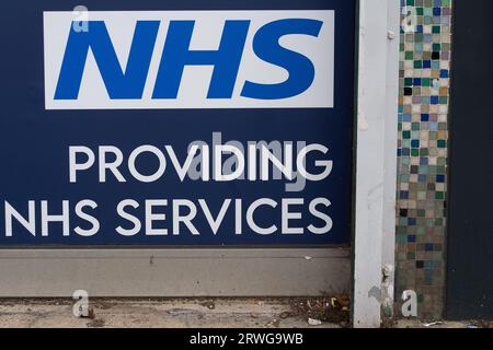 Slough, Berkshire, Großbritannien. September 2023. Ein NHS-Schild in einer Apotheke in Slough, Berkshire. Menschen ab 65 Jahren werden dringend aufgefordert, ihre COVID-19-Booster-Jabs für den Herbst zu besorgen, da die Fälle im gesamten Vereinigten Königreich weiter zunehmen. Die Einführung der Herbstimpfungen wurde als Vorsichtsmaßnahme gegen eine hochgradig mutierte neue COVID-Variante namens BA.2,86 vorgezogen. Viele Menschen, die unter 65 Jahre alt sind, befürchten, dass sie nicht mehr für eine COVID-19-Auffrischungsimpfung oder eine Grippeschutzimpfung in Frage kommen, da die Regierung offenbar die Kosten senkt. Kredit: Maureen McLean/Alamy Stockfoto