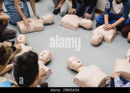 Kardiopulmonaler Reanimationskurs in der Grundschule. Kinder, die an Reanimationspuppen üben. Stockfoto