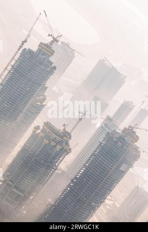 Riesige skyscrappers Baustelle mit Kränen auf Gebäuden. Rapid urban und Bauwirtschaft die Entwicklung oder die Inflation der Immobilienblase. Stockfoto