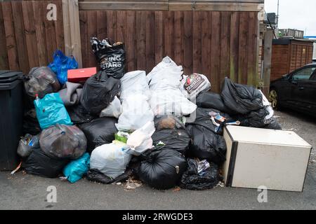 Slough, Berkshire, Großbritannien. September 2023. Der heute oft vertraute Anblick von Müll stapelte sich auf der Straße in Slough, Berkshire. Das Slough Borough Council in Berkshire hat eine Änderung der Mülltonnen der Bewohner eingeführt, um die Bewohner zu ermutigen, mehr Recycling zu betreiben. Graue Abfallbehälter mit allgemeinen Abfällen, einschließlich Lebensmitteln, werden jetzt einmal alle 14 Tage anstatt einmal pro Woche gesammelt, wobei das Recycling in roten Abfallbehältern erfolgt, die in der zweiten Woche gesammelt werden. Dies führt dazu, dass überlaufene Mülltonnen und Taschen mit Fliegenspitzen voller Müll auf den Bürgersteigen in der Stadt verstreut bleiben. Kredit: Maureen McLean/Alamy Stockfoto