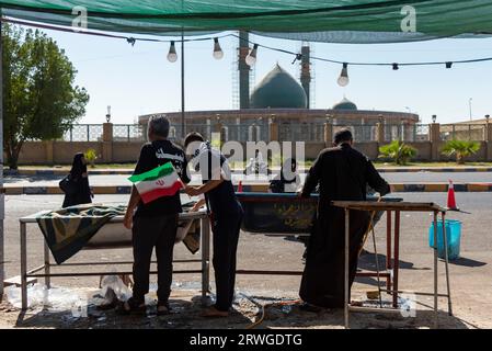 Najaf, Irak. September 2023. Irakische Schiiten verteilen Wasser unter schiitischen Pilgern, die von Najaf in Richtung der Schreinerstadt Karbala marschieren. Jedes Jahr pilgern Millionen schiitische Muslime und einige aus anderen Glaubensrichtungen zu Fuß von verschiedenen Städten im Irak und Iran in die heilige Stadt Karbala. Diese Pilgerfahrt erinnert an Imam Hussein, den Enkel des Propheten Mohammed, der 680 n. Chr. in einer Schlacht starb. Am 40. Tag der Trauer um Hussein, bekannt als Arbaeen, kommen Pilger in Karbala zusammen, um an seinem Heiligtum Tribut zu zollen. Auf dem Weg stellen Freiwillige Nahrung, Wasser und Sch zur Verfügung Stockfoto