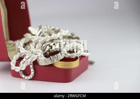 Gold- und Silberschmuck in einer Box. Silberne Kette und Ring sowie ein goldener Ring im Stapel Stockfoto