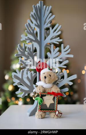 Teddybär unter dem Weihnachtsbaum hält an der Hoffnung fest Stockfoto