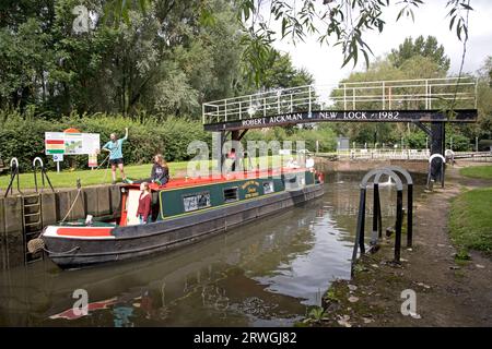 Junge Urlauber, die sich auf einem Lastkahn nähern, nähern sich der Robert Eichman-Brücke und der Schleuse auf dem Fluss Avon bei Offenham UK Stockfoto