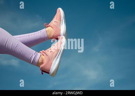 Nahaufnahme von pinken Sportschuhen vor blauem Himmel, Fitnesskonzept Stockfoto