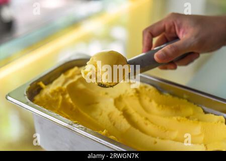 Einen Messlöffel Passion Fruit Ice in einen Löffel im Kühlschrank geben Stockfoto