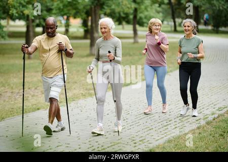 Gruppe von Senioren, die skandinavische Spaziergänge im Freien im Park machen Stockfoto