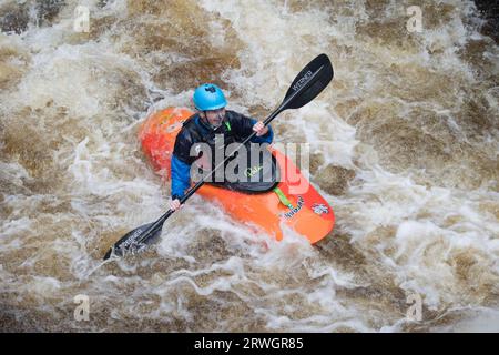 Kanufahren im orangen Kanu auf den Stromschnellen Whitewater Slalom Kanufahren im River Tryweryn im National Whitewater Centre in der Nähe von Bala North Wal Stockfoto