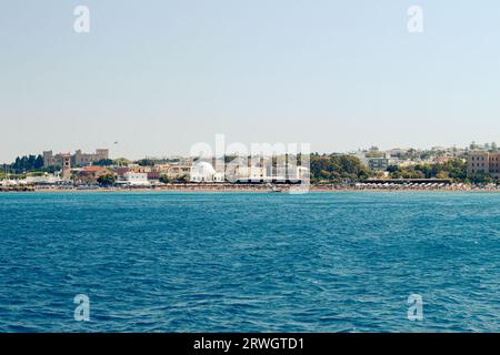 Beliebter Elli Strand oder Paralia Enidriou auf der Insel Rhodos in Griechenland, Europa. Beliebter Sandstrand in der Stadt an sonnigen Sommertagen, klarer blauer Himmel. Stockfoto