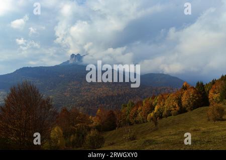Der Ceahlau Mountain im rumänischen Neamt hat von weitem beobachtet, da er vor dem Regen von Wolken bedeckt war, an einem wunderschönen Oktobertag. Stockfoto