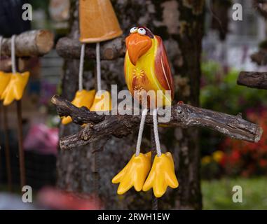 Leuchtend gelber Spielzeug-Keramik-Vogel mit großen Pfoten zum Verkauf auf dem Straßenmarkt Stockfoto