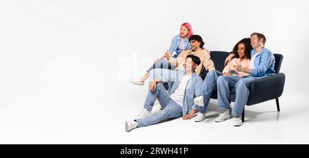 Glückliche Teenager-Freunde, die Filme ansehen, auf Sofa und Boden sitzen, freien Platz, Panorama, Banner sehen Stockfoto