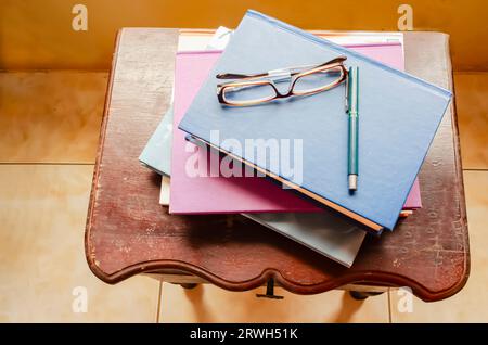 Bücher Stift und Brille auf Nachttisch Stockfoto