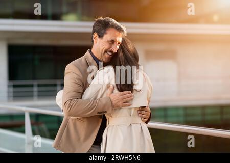 Ein Paar mittleren Alters, Mann und Frau, die sich auf der Straße umarmen Stockfoto