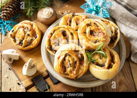 Italienische Vorspeisen. Pizza rollt Blätterteig gefüllt mit Prosciutto-Speck, Pilzen und Käse auf dem Weihnachtstisch. Stockfoto