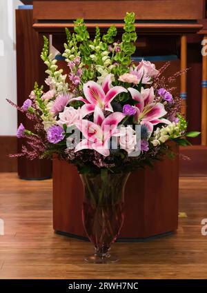 Wunderschönes Blumenarrangement in einer schönen Vase mit rosa Sternenlilien, rosa Rosen und lila Nelken im St. Josephs katholische Kirche, Stockfoto