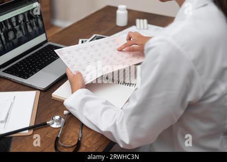 Der Arzt überprüft die Testergebnisse anhand von Bildern und Dokumenten der Magnetresonanztomographie des Patienten Stockfoto