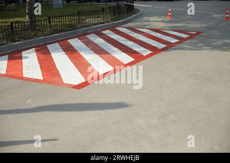 Plattform für Feuerlöschgeräte. Parkplätze für Feuerwehrleute. Asphalt wird in Streifen lackiert. Rot-weiße Streifen auf der Straße. Stockfoto