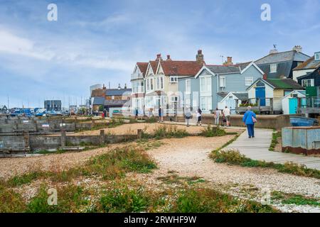 Whitstable, Großbritannien - 12. September 2023 Touristen und Einheimische spazieren entlang des hölzernen Pfades am Meer vor der unverwechselbaren Architektur von Whtistable Stockfoto