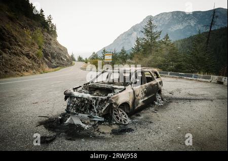 Ein verbranntes Auto an der Seite der Duffy Lake Road zwischen Pemberton und Lillooet BC. Fahrzeugbrände sind auf der steilen, kurvenreichen Autobahn häufig. Stockfoto