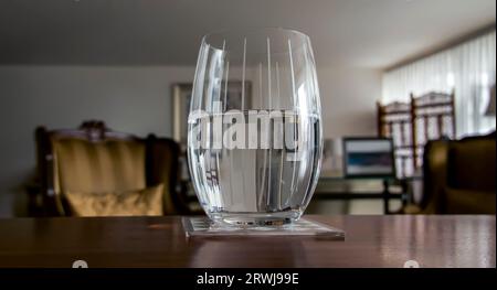 Glas halb voll mit Wasser verschwommener Hintergrund Stockfoto