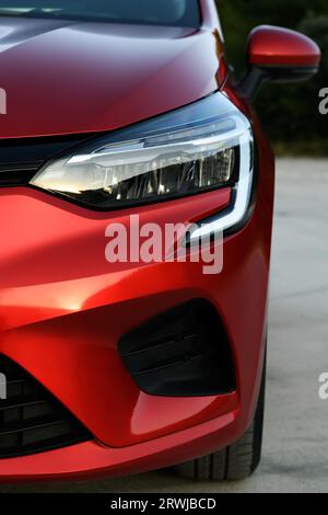 Izmir, Türkei - 2. August 2023: Ein detailliertes Nahaufnahme-Foto, das das Scheinwerferdesign eines roten Renault Clio aufnimmt und dessen schlanke und moderne Optik unterstreicht Stockfoto