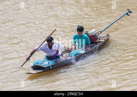 PRACHIN BURI, THAILAND, FEBRUAR 26 2023, Ein Fischer in einem kleinen Boot fängt Fische mit einem Netz Stockfoto