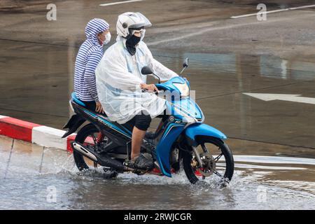 SAMUT PRAKAN, THAILAND, 12. MAI 2023, Mototaxi fährt mit einem Passagier bei Regen Stockfoto