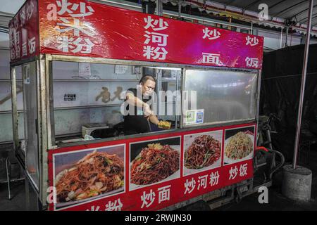 Guangzhou, China. Juli 2023. Ein Mann kocht auf einem Nachtmarkt. (Credit Image: © Michael Ho Wai Lee/SOPA Images via ZUMA Press Wire) NUR REDAKTIONELLE VERWENDUNG! Nicht für kommerzielle ZWECKE! Stockfoto