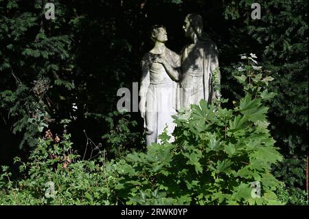 Köln, Deutschland. September 2023. Figur auf einem bewachsenen Grab auf dem Kölner Friedhof für Prominente Melaten Credit: Horst Galuschka/dpa/Horst Galuschka dpa/Alamy Live News Stockfoto