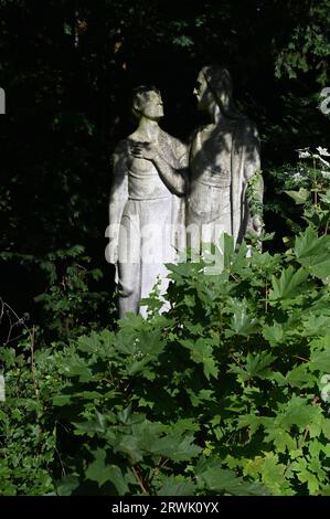 Köln, Deutschland. September 2023. Figur auf einem bewachsenen Grab auf dem Kölner Friedhof für Prominente Melaten Credit: Horst Galuschka/dpa/Horst Galuschka dpa/Alamy Live News Stockfoto