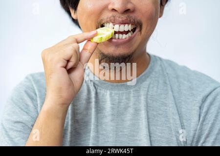 Mann, der Gurke mit weißem Hintergrund isst. Traditionelles indonesisches Essen Stockfoto