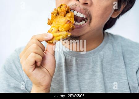 Mann, der Pecel Ayam mit weißem Hintergrund isst. Traditionelles indonesisches Essen Stockfoto