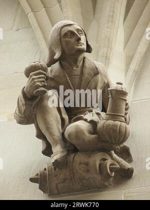 Kniende Figur aus Sandstein mit Kelch und Kanne in einem historischen Gebäude Stockfoto