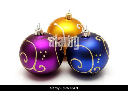 Goldene, lila und dunkelblaue weihnachtskugeln mit Goldmuster isoliert auf weißem Hintergrund Stockfoto