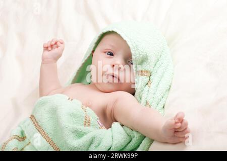 Zehn Wochen alte süße kleine Baby Mädchen Kleinkind in Handtuch streckte ihre Arme gewickelt Stockfoto