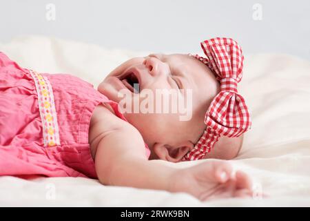 Zehn Wochen alten Babymädchen auf Bett Weinen Stockfoto