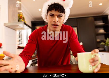 Glücklicher Biracial-Mann in santa hat Videoanruf Stockfoto