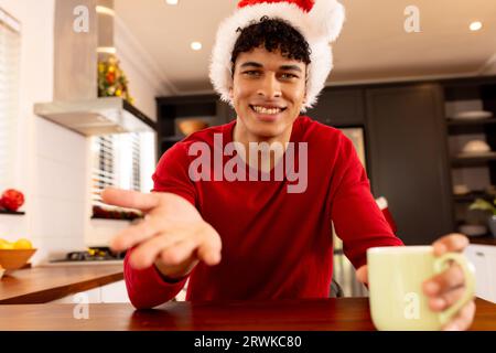 Glücklicher Biracial-Mann in santa hat Videoanruf Stockfoto