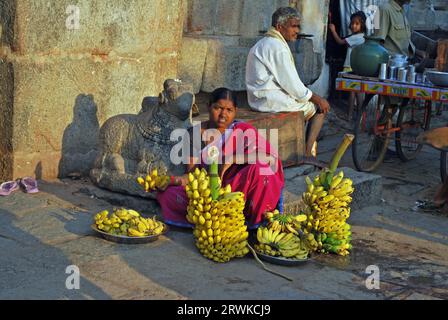 Indische Frau, die Bananen vor dem Tempel in Hampi, Karnataka, Südindien verkauft Stockfoto