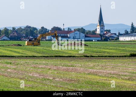 PRODUKTION - 15. September 2023, Bayern, Straßkirchen: Ein Feld zwischen Irlbach und Straßkirchen, im Hintergrund die Pfarrkirche St. Stephanus in Straßkirchen. BMW will 40 Kilometer nördlich seines größten europäischen Automobilwerks in Dingolfing eine Batteriefabrik errichten. Foto: Armin Weigel/dpa Stockfoto