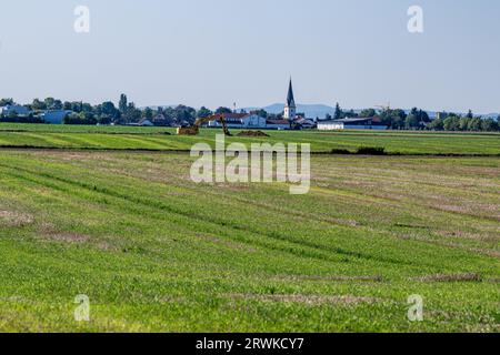 PRODUKTION - 15. September 2023, Bayern, Straßkirchen: Ein Feld zwischen Irlbach und Straßkirchen, im Hintergrund die Pfarrkirche St. Stephanus in Straßkirchen. BMW will 40 Kilometer nördlich seines größten europäischen Automobilwerks in Dingolfing eine Batteriefabrik errichten. Foto: Armin Weigel/dpa Stockfoto