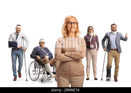 Reife Frau, die vor einer Gruppe von Verletzten auf weißem Hintergrund steht Stockfoto
