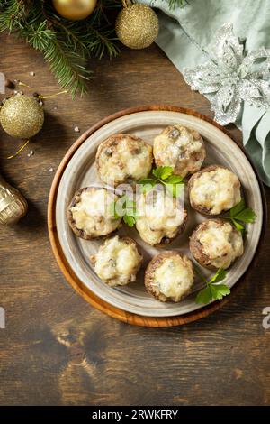 Traditionelles polnisches Weihnachtsgericht auf dem Tisch. Gebackene Pilze, gefüllt mit Fleisch, Speck und Käse. Ansicht von oben. Leerzeichen kopieren. Stockfoto