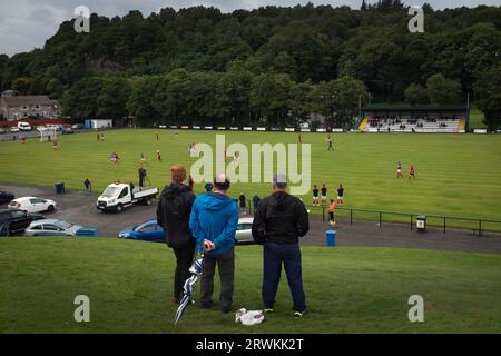 Die Zuschauer sehen sich die Action in der ersten Hälfte an, während Oban Camanachd Kingussie in einem glanzvollen Spiel der Premiership im Mossfield Park in Oban spielt. Die Heimmannschaft wurde 1889 gegründet und war schon immer einer der führenden Vereine in diesem Sport, der fast ausschließlich in Schottland spielte. Die Besucher gewannen diese Begegnung in der obersten Liga mit 2 Toren zu 1, beobachtet von einer Menge von rund 100 Zuschauern. Stockfoto