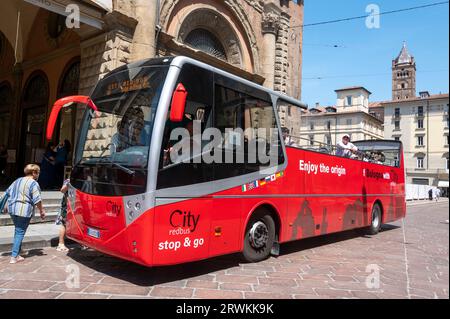 Ein einstöckiger Stadtbus mit rotem Oberdeck am Start- und Endpunkt einer Bologna-Tour auf der Piazza Maggiore in Bologna in der Region Emilia-Romagna im Norden Stockfoto