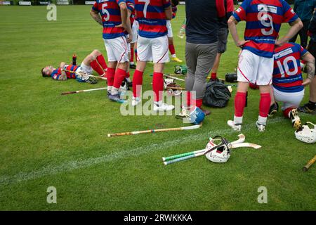 Die Spieler des Auswärtsteams versammeln sich am Ende des Spiels auf dem Spielfeld, während Oban Camanachd Kingussie in einem glanzvollen Spiel der Premiership im Mossfield Park in Oban spielt. Die Heimmannschaft wurde 1889 gegründet und war schon immer einer der führenden Vereine in diesem Sport, der fast ausschließlich in Schottland spielte. Die Besucher gewannen diese Begegnung in der obersten Liga mit 2 Toren zu 1, beobachtet von einer Menge von rund 100 Zuschauern. Stockfoto