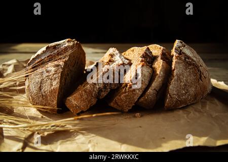 Frisch gebackenes traditionelles Brot auf einem Holztisch. Roggenbrot in Scheiben, Nahaufnahme. Lebensmittelhintergrund. Stockfoto