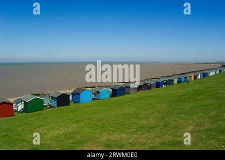 Tankerton Beach kleine Häuser an Tankerton Hängen an der Küste von Whitstable, Kent, Großbritannien. Erhöhte Holzhütten mit Meerblick an einem sonnigen Tag mit blauem Himmel Stockfoto