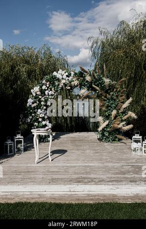 Wunderschöner runder Hochzeitsbogen mit Blumen Stockfoto